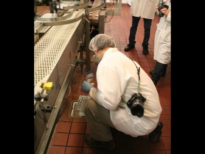 Epidemiologists swab floor drains in the milk processing facility.