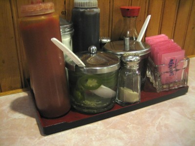 Tray of accoutrements for Phở (Vietnamese noodle soup) including a shaker of the infamous Lian How white pepper.